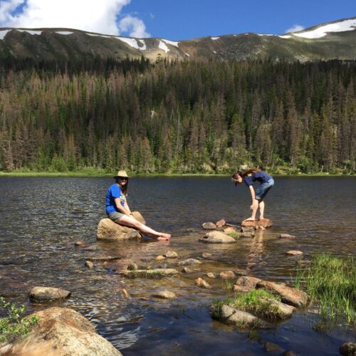 Two girls swim in a high alpine lake near Salida Colorado